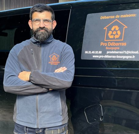 Homme devant un véhicule de débarras